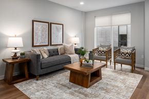 Chesterfield apartment for rent - A living room with a grey couch, two chairs, a coffee table, and two lamps.