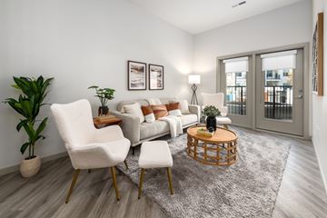 St. Louis apartment for rent - A living room with a grey rug, a white sofa, a white chair and a wooden coffee table.