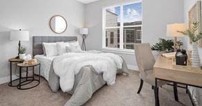 Olivette apartment for rent - A bedroom with a grey bedspread and a round mirror on the wall at The Oliver Apartments, Missouri