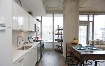 St. Louis apartment for rent - A kitchen with white cabinets and a wooden table.