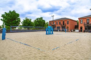 A sandy volleyball court with blue lines and a blue net