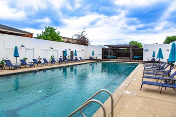 A pool with blue umbrellas and chairs