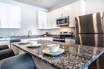 A kitchen with granite countertops and stainless steel appliances