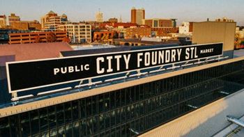 A public city foundry sign on the top of a building