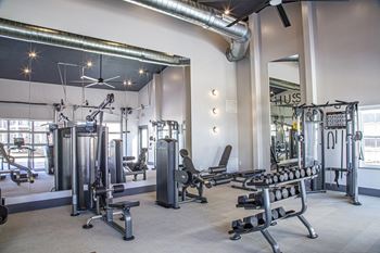 A gym with weights and other exercise equipment and a large window