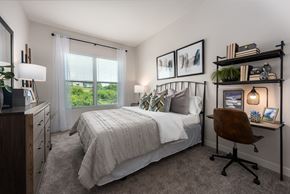 Saint Charles apartment for rent - Modern bedroom with large window, bed, dresser and small work station  at Chapter at the Streets of St Charles, Saint Charles, MO, 63303