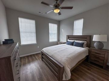 St. Charles apartment for rent - A bedroom with a large bed and a ceiling fan.