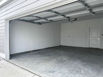 A garage with a white door and a concrete floor
