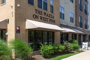 Saint Louis apartment for rent - The Plazza on West Pine is a multi-story building with a beige facade and a white awning.