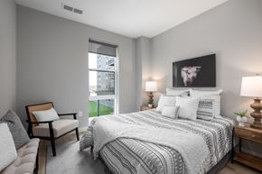 Saint Louis apartment for rent - bedroom with gray walls and a large bed with white comforter and pillows at The Edwin on Grand Apartments, St Louis, Missouri