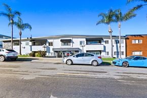 Redondo Beach apartment for rent - A parking lot with cars and a building in the background.