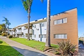 Redondo Beach apartment for rent - A row of modern apartment buildings with palm trees in front.