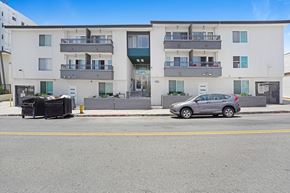 Hollywood apartment for rent - A car is parked on the side of a street in front of a building.