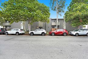 Los Angeles apartment for rent - Four cars parked in a row in front of a building.