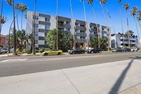 Santa Monica apartment for rent - A yellow car is parked on the side of the road in front of a building.
