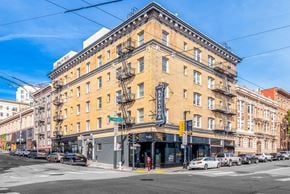 San Francisco apartment for rent - A street view of a city with a yellow building in the center.
