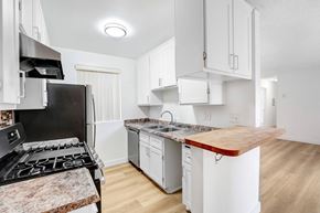 Los Angeles apartment for rent - A kitchen with a black stove top oven and white cabinets.