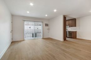 West Hollywood apartment for rent - A spacious room with wooden flooring and a sliding door leading to a balcony.