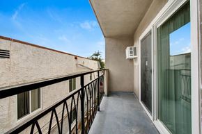 West Hollywood apartment for rent - A balcony with a black railing and a glass door.
