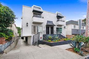 West Hollywood apartment for rent - A white two-story house with a black gate and plants in front.