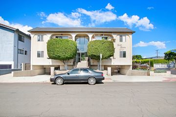 Mar Vista apartment for rent - A car is parked in front of a two-story building with green plants on the front.