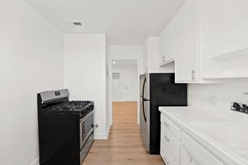 Los Angeles apartment for rent - A black stove and refrigerator in a white kitchen.