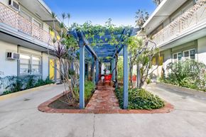 Los Angeles apartment for rent - A walkway with a blue canopy and plants on either side.