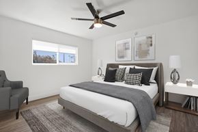 Los Angeles apartment for rent - A bedroom with a large bed, a ceiling fan, and a chair.