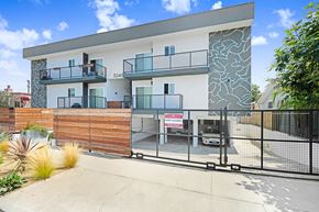 Los Angeles apartment for rent - A modern two-story house with a balcony and a fence.