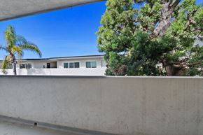 Redondo Beach apartment for rent - A house with a white wall and a tree in front of it.