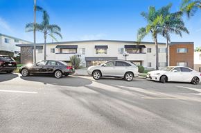 Redondo Beach apartment for rent - A black car is parked in a parking lot in front of a white building.