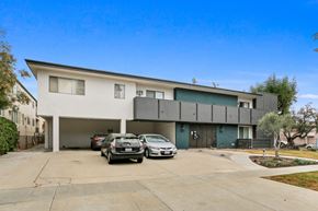 Los Angeles apartment for rent - A modern two-story house with a garage and two cars parked in front.