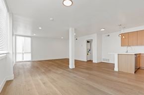 Santa Monica apartment for rent - A spacious room with wooden flooring and white walls.