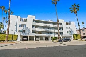Santa Monica apartment for rent - A modern white building with palm trees in front.