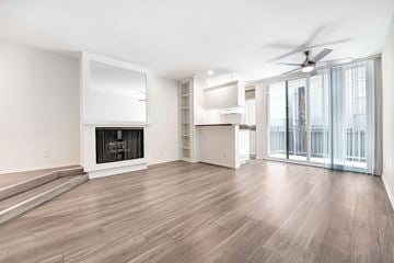 West Hollywood apartment for rent - A spacious living room with a fireplace and sliding glass doors.