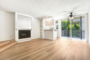 West Hollywood apartment for rent - A spacious living room with a fireplace and sliding glass doors.
