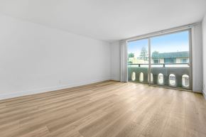 Santa Monica apartment for rent - A room with wooden flooring and a large window overlooking a building.
