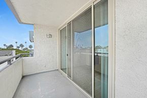 Santa Monica apartment for rent - A balcony with a glass door and a railing.