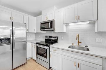 Santa Monica apartment for rent - A modern kitchen with white cabinets and stainless steel appliances.