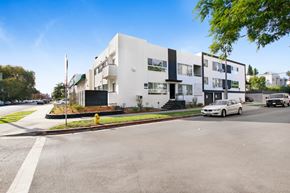 Los Angeles apartment for rent - A white building with black accents sits on a street corner.