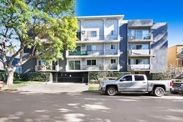 Los Angeles apartment for rent - A silver truck is parked in front of a modern apartment building.