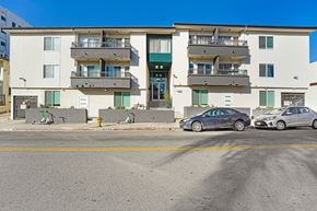 Hollywood apartment for rent - Two cars parked in front of a white apartment building.