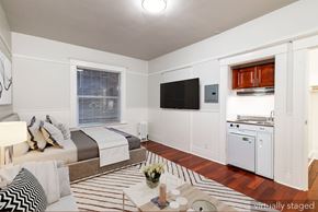 San Francisco apartment for rent - A bedroom with a bed, a television, and a striped rug.