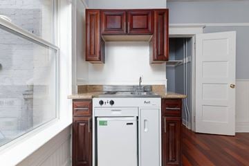 San Francisco apartment for rent - A white dishwasher is in a kitchen with brown cabinets.