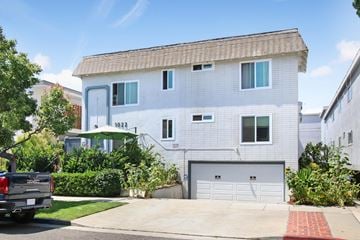 Santa Monica apartment for rent - A white two-story house with a garage and a truck parked in front.