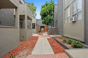 Los Angeles apartment for rent - A pathway with red bricks leads to a building with a brown door.