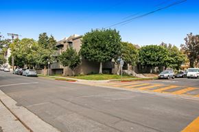 Los Angeles apartment for rent - A street view with cars, trees, and buildings.