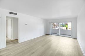 Los Angeles apartment for rent - A room with a white wall and a window with a view of trees and a building outside.