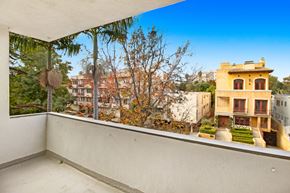 Los Angeles apartment for rent - A balcony with a view of a yellow building and trees.
