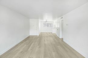 Los Angeles apartment for rent - A long, empty hallway with wooden floors and white walls.